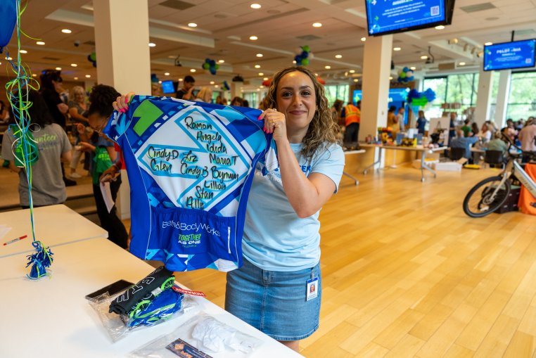 Bath & Body Works associate posing for a photo holding up a t-shirt