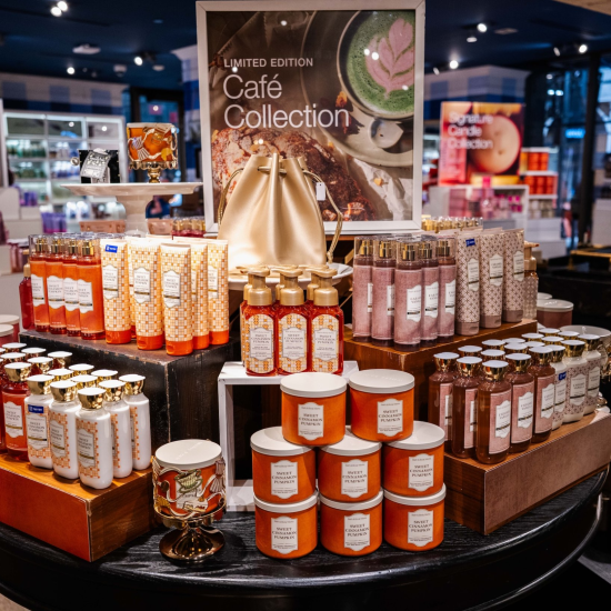 Cafe Collection product stand with candles, body cream, fine fragrance mists, hand soaps lotion and body wash in a Bath & Body Works store
