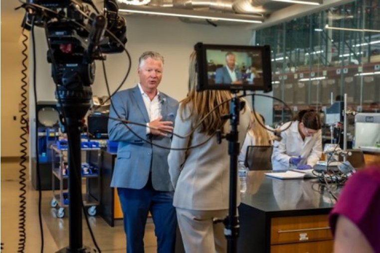 Journalist interviewing Bath & Body Works executive in a research lab