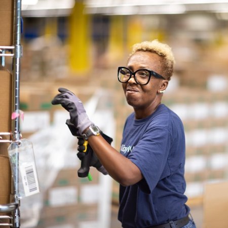 BBW employee in a distribution center with a scanner in hand