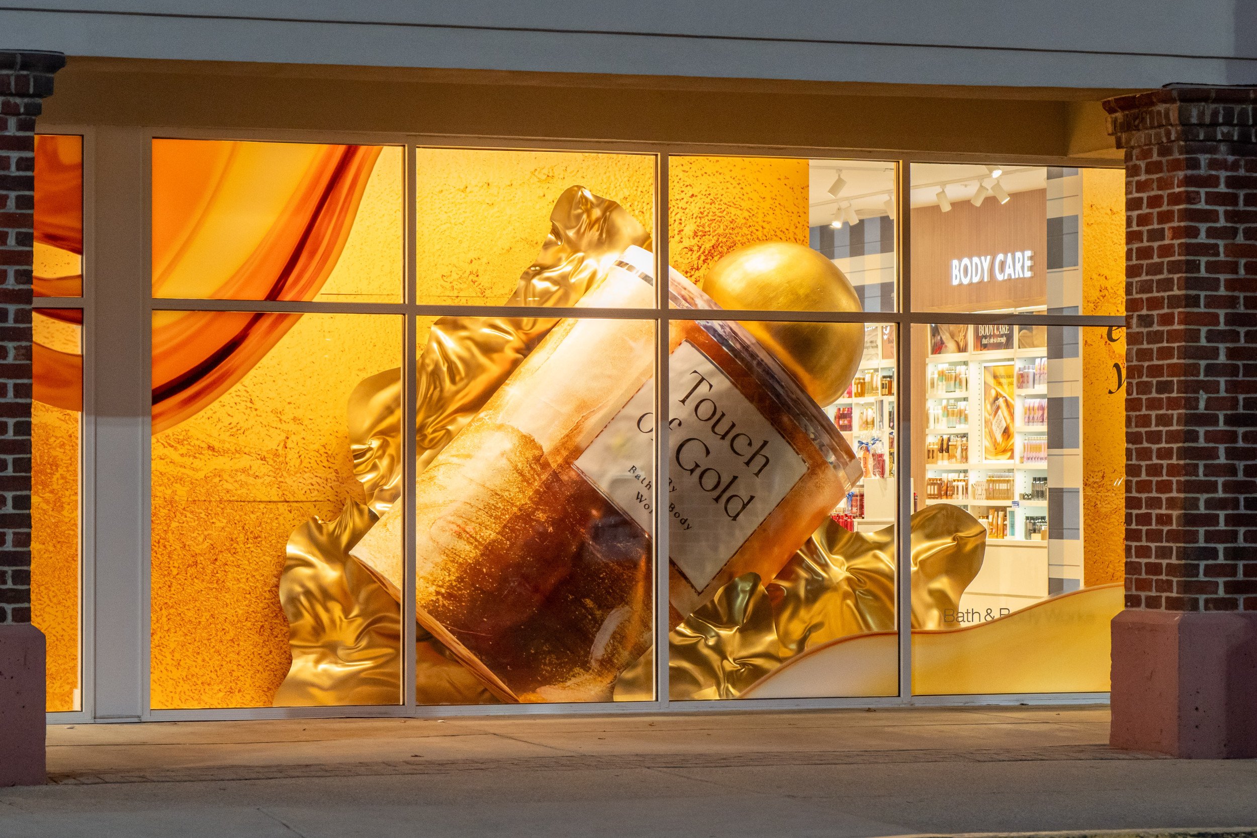 Bath & Body Works store windows with Touch of Gold product decor