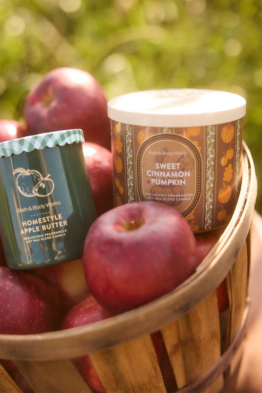 Sweet Cinnamon Pumpkin and Homestyle Apple Butter candles in a basket of apples
