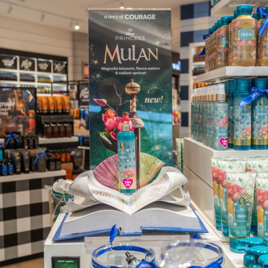 Disney Mulan fragrance on top of a story book in a Bath & Body Works store