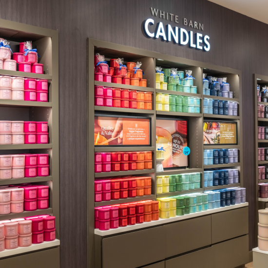Wall of 3-wick candles in a Bath & Body Works store