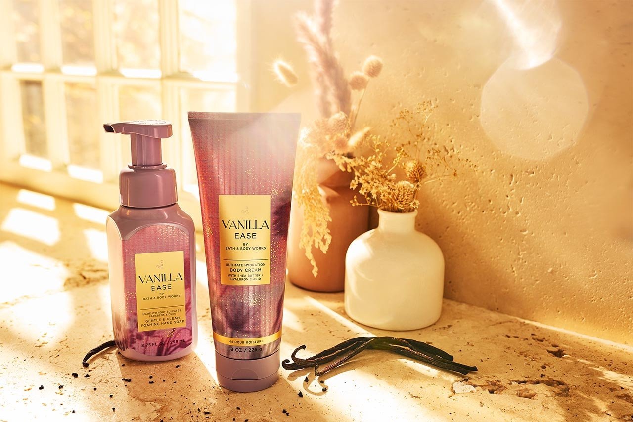 Bath & Body Works vanilla body care products on stone background, with vanilla and warm lighting